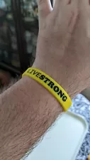 yellow nike silicone bracelet that said live strong