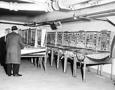 An Internal Revenue Service agent looks over pinball machines s- 1962 Old Photo