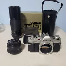 CANON AV-1 Silver 35 mm SLR {New in Box), 50mm 1:1.8 Lens, 100-200 !:5.6 Zoom,