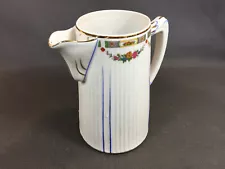 Old porcelain teapot with flower pattern and blue border