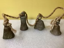 four small antique bronze bells.