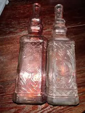 2 12.”Tall Glass Bottle in Red w/Raised Design on Front & Back