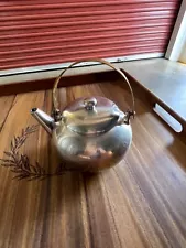 Small silver teapot with brass handle. very unique