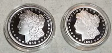 (2) DIFFERENT PROOF MORGAN SILVER DOLLAR TRIBUTE PIECES IN HARD PLASTIC CAPSULES