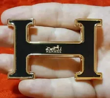 HERMES. Belt buckle with "HERMES" inscription. Gold-black tone. New