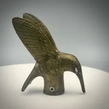 Vintage solid bronze hummingbird sculpture resting on an outdoor garden faucet.